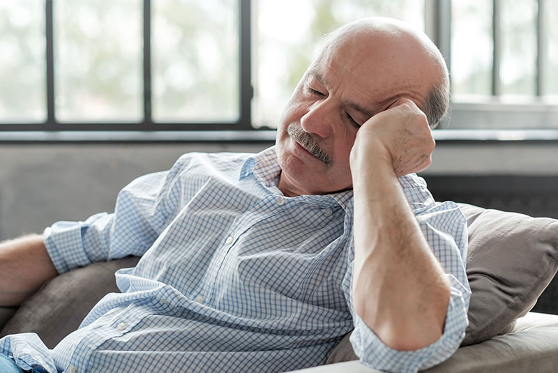 older man sleeping outside of the dental practice